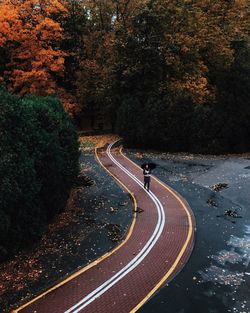 High angle view of woman walking on footpath during autumn