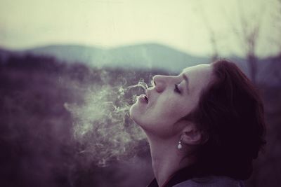 Close-up of woman exhaling smoke