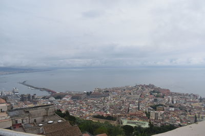 High angle view of townscape by sea against sky