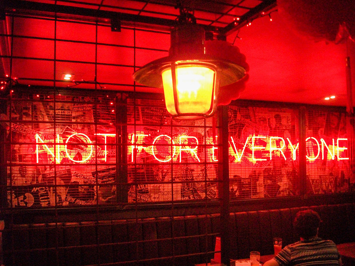 CLOSE-UP OF ILLUMINATED TEXT ON RED WALL