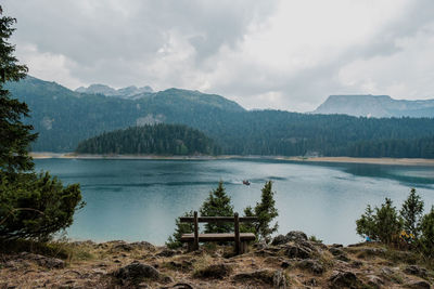 Scenic view of lake by mountains against sky