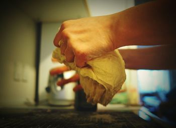 Cropped hands kneading dough