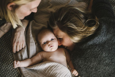 Mothers lying in bed with newborn baby