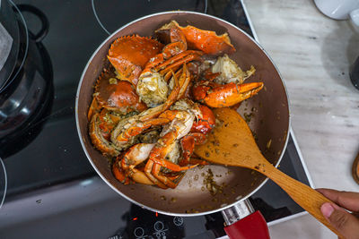 Overhead view photo of human cooking stir-fried crab with pepper