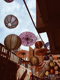 Low angle view of umbrellas hanging against sky