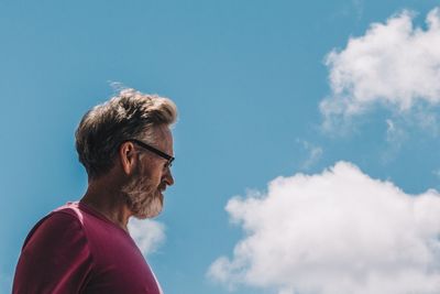 Low angle portrait of young man against blue sky