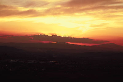 Scenic view of silhouette mountains against romantic sky at sunset