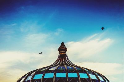Low angle view of carousel against sky