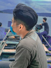 Rear view of boy sitting on boat