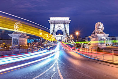 The chain bridge in budapest at night. moving lights of the cars.
