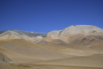 Scenic view of snowcapped mountains against clear blue sky