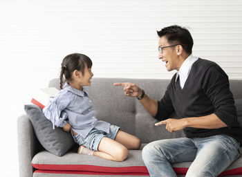 Side view of father and son sitting on ground