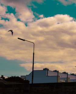 Low angle view of street lights against sky at sunset