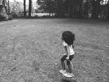 Full length of girl walking with basket on grass