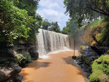 Scenic view of waterfall against sky