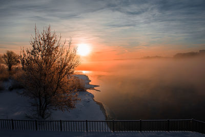 Scenic view of lake during foggy sunrise