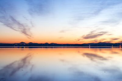 Scenic view of lake against sky at sunset