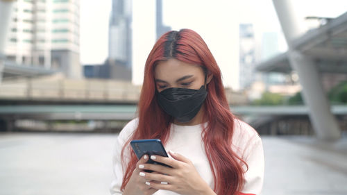 Young woman using mobile phone in city