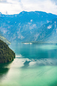 Scenic view of lake by mountains against sky