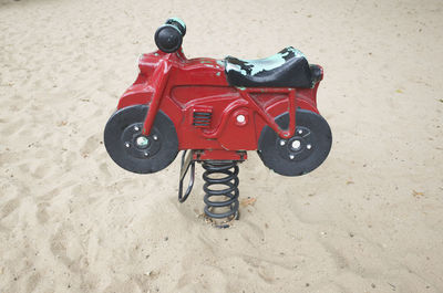 Close-up of red toy car on sand