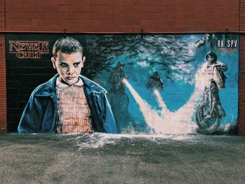 Portrait of young man against graffiti on wall