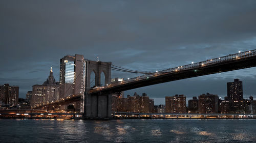 Illuminated bridge over river at night,new york skyline at night