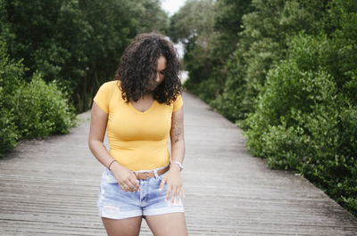 Woman standing on footpath amidst plants