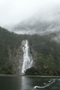 Scenic view of waterfall against sky