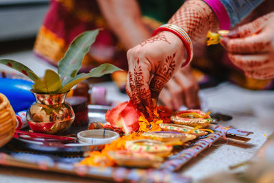 Cropped hands of women performing rituals on floor