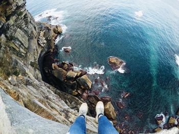 High angle view of people on rock by sea