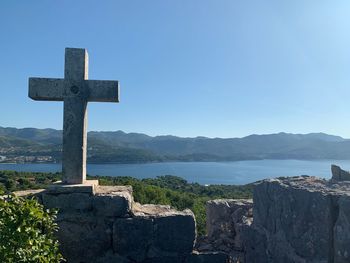 Cross on mountain against blue sky