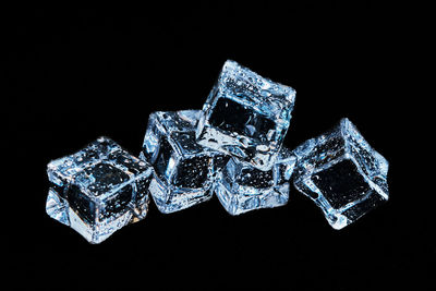 Close-up of ice on table against black background