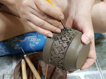 Close-up of person carving on earthenware