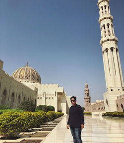 Portrait of man standing against building