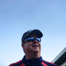 Low angle view of sunglasses against clear blue sky