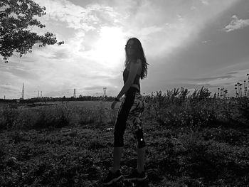 Woman standing on field against sky