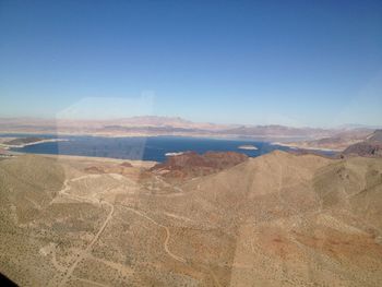 Scenic view of desert against clear blue sky