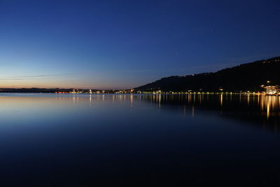 Scenic view of lake against clear blue sky at night