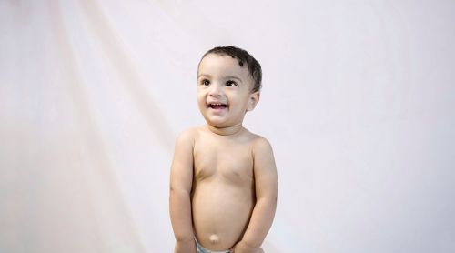 Portrait of happy boy standing against white background