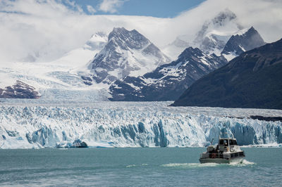 Perito moreno glacier with small boat passing by.