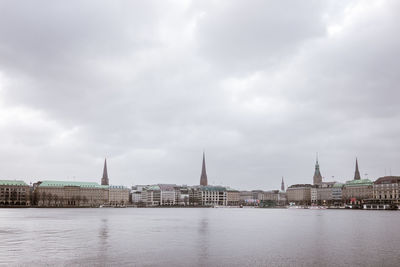 Buildings by river against sky