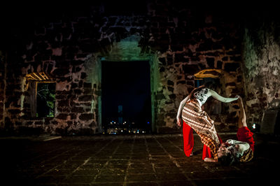 Full length of young woman standing against wall