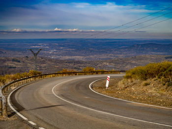 Road leading towards mountain against sky