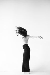 Young woman standing against white background