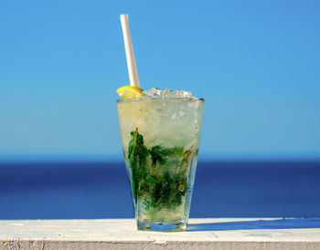 Close-up of drink on table against swimming pool