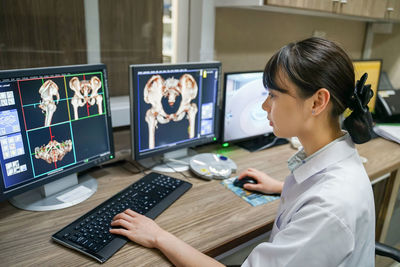 Midsection of woman using smart phone on table