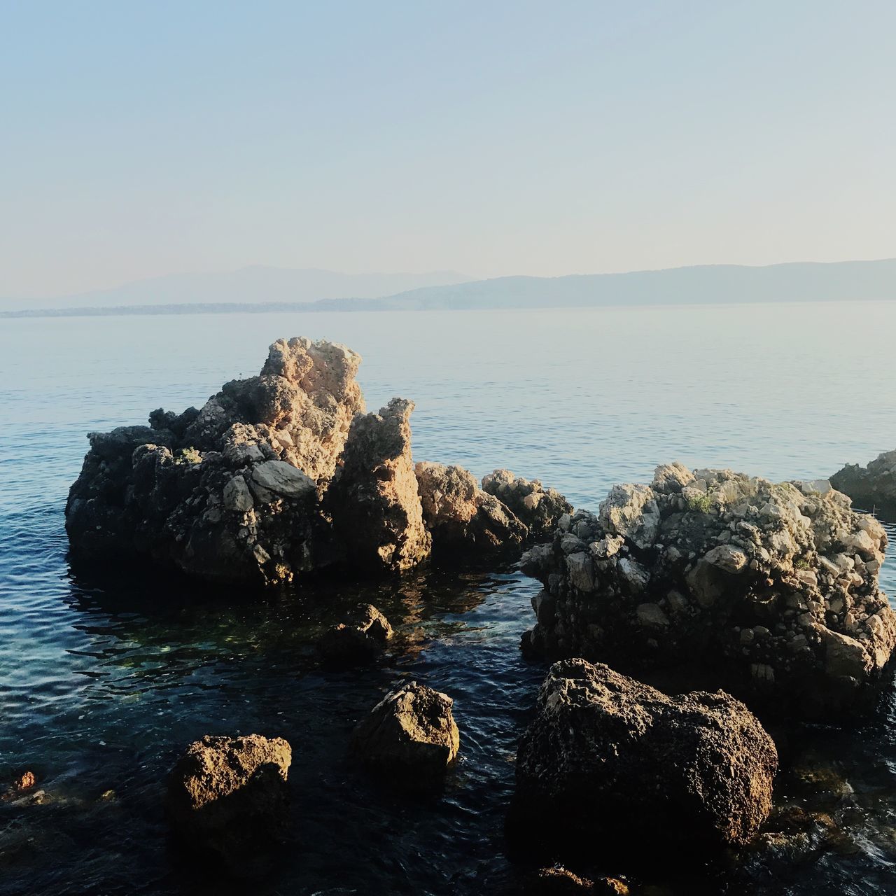 ROCK FORMATION IN SEA AGAINST SKY