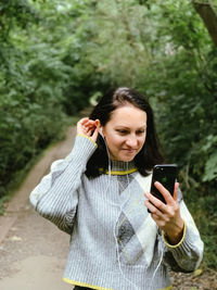 Young woman is walking in the park and talking to her friends with using video chat.casual lifestyle