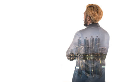 Double exposure image of businessman and city against white background
