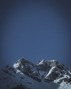 Scenic view of snowcapped mountains against clear blue sky